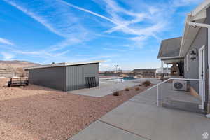 View of yard featuring a community pool, a patio area, a mountain view, and an outdoor structure
