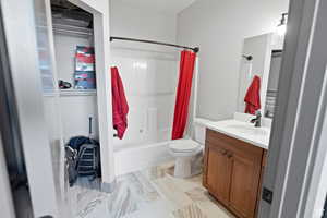 Bathroom featuring shower / bath combo with shower curtain and vanity