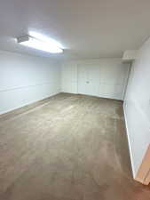 Finished basement with carpet flooring and a textured ceiling