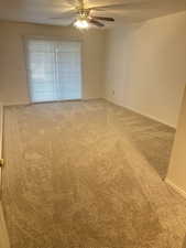 Empty room with carpet floors and a ceiling fan