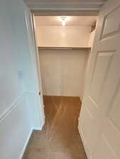 Walk in closet in Family Room featuring light carpet