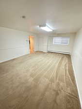 Family Room  with light colored carpet, a textured ceiling, and a baseboard heating unit