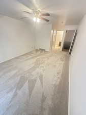 Unfurnished room featuring light colored carpet and ceiling fan