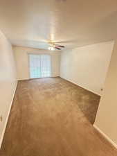 Primary Bed room featuring carpet flooring, a textured ceiling, and ceiling fan