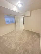 Unfurnished room with a textured ceiling and carpet