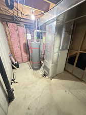 Unfinished below grade area featuring gas water heater and heating unit