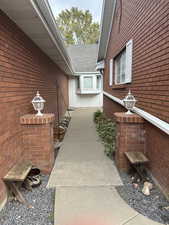 Property entrance with brick siding and a shingled roof