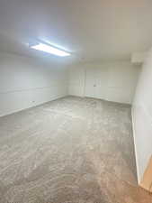 Additional living space with carpet floors and a textured ceiling