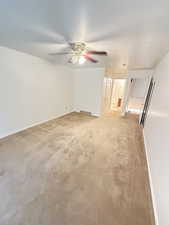 Primary Bedroom  with light colored carpet, ceiling fan, and a textured ceiling
