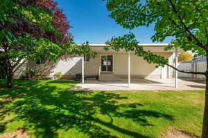 Back of property featuring a yard and a patio