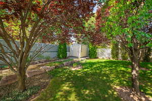 Fenced backyard featuring a storage shed