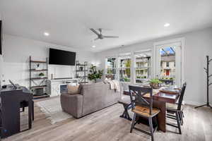 Living room with light wood-type flooring, ceiling fan, and recessed lighting