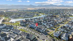 Aerial view of property and surrounding area featuring nearby suburban area and a water and mountain view