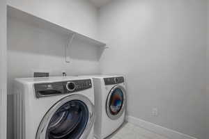 Laundry area with washing machine and dryer and light marble finish floors