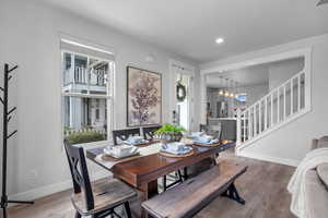 Dining room with stairway, hardwood / wood-style flooring, a chandelier, and recessed lighting