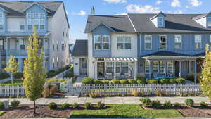 View of front of home with a fenced front yard and roof with shingles