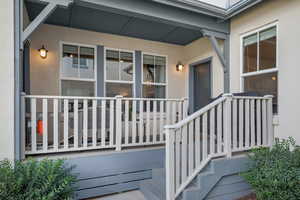 Entrance to property with stucco siding and covered porch