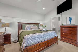Bedroom featuring light carpet, ceiling fan, ensuite bathroom, recessed lighting, and a decorative wall