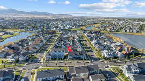 Aerial view of property and surrounding area featuring a large body of water and nearby suburban area