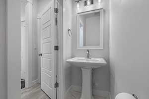 Half bath featuring baseboards and light wood-style floors