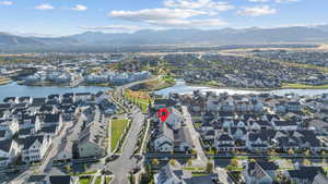 Aerial view of property and surrounding area featuring nearby suburban area and a water and mountain view