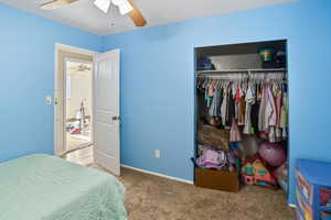 Bedroom featuring carpet flooring, a closet, and a ceiling fan