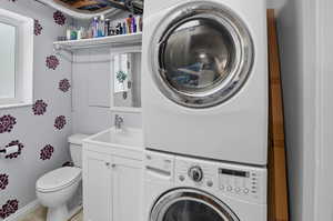 Laundry room with stacked washer / drying machine and a sink