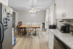 Dining space with ceiling fan, light wood-type flooring, and a textured ceiling