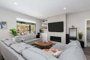 Living area featuring recessed lighting, a premium fireplace, and wood finished floors