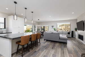 Kitchen with a center island, hanging light fixtures, dark wood-style floors, and recessed lighting