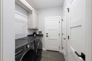 Washroom featuring cabinet space and washing machine and dryer