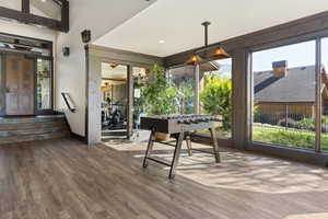 Playroom with healthy amount of natural light, wood finished floors, vaulted ceiling, and recessed lighting
