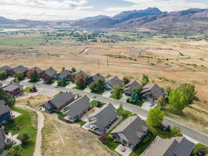 Aerial view of property and surrounding area featuring a mountainous background and nearby suburban area