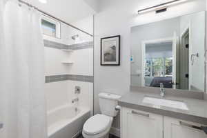Full bathroom with shower / tub combo with curtain, connected bathroom, and vanity
