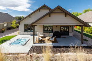 Back of property featuring a patio and stone siding