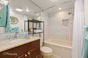 Full bathroom with shower / tub combo with curtain, vanity, and a textured ceiling