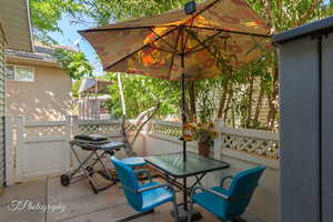 View of patio / terrace featuring outdoor dining area, a wooden deck, and a grill