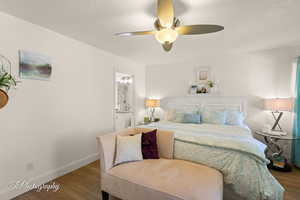 Bedroom with wood finished floors, connected bathroom, and ceiling fan