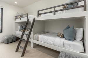 Bedroom featuring light carpet, lofted ceiling, and recessed lighting