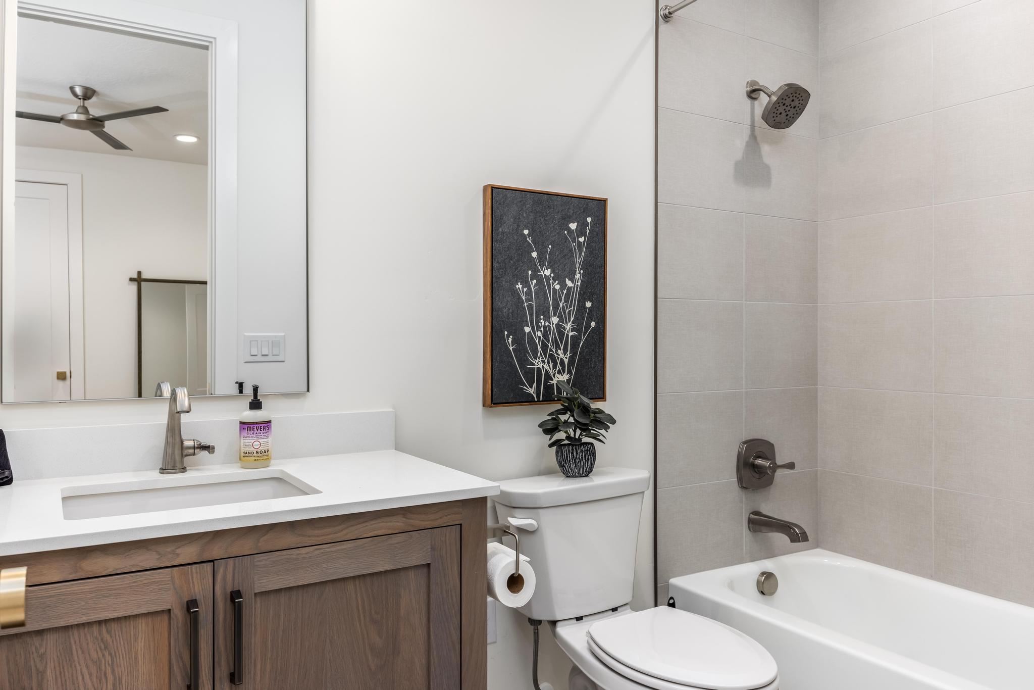 Bathroom with vanity, tub / shower combination, and a ceiling fan
