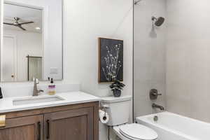 Bathroom with vanity, tub / shower combination, and a ceiling fan