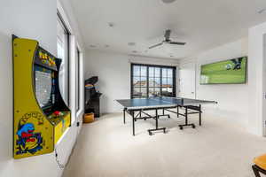 Game room featuring healthy amount of natural light, light carpet, and a ceiling fan