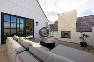 View of patio featuring an outdoor stone fireplace