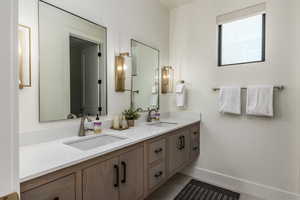 Full bath featuring double vanity and baseboards