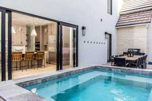 View of swimming pool with outdoor dining area, a patio area, and a pool