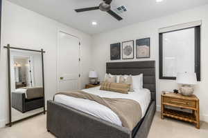 Carpeted bedroom featuring a ceiling fan, ensuite bath, and recessed lighting