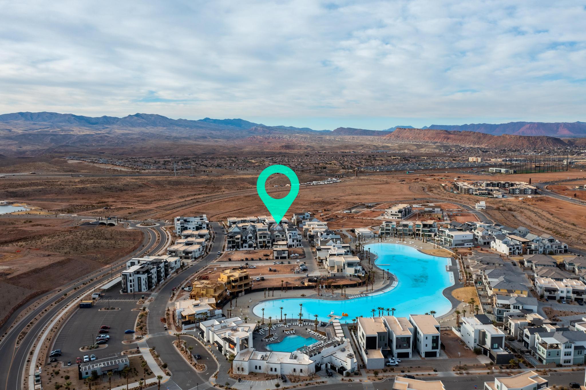 Aerial view of property's location featuring a mountain backdrop and a pool area