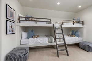 Carpeted bedroom with recessed lighting and lofted ceiling