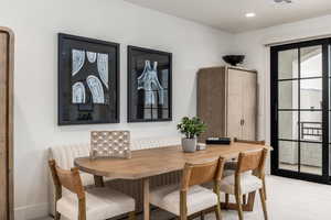 Dining room with light carpet and recessed lighting