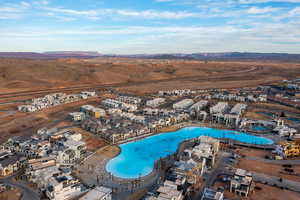 Aerial perspective of suburban area featuring a pool and a mountain backdrop